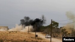 NTC fighters drive to take cover from shelling about 500 meters from the entrance to Sirte on October 2.