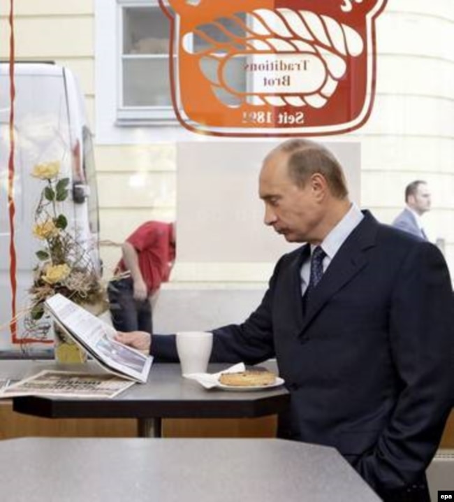 Putin reads a German newspaper in a coffeeshop in Dresden in October 2006.