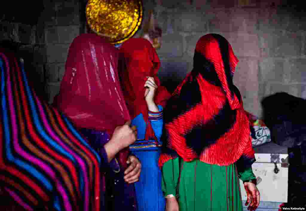 Afghan women cover their faces at their temporary home in Kabul. They are among nearly 90,000 Afghan refugees who have returned from Pakistan in recent months. &nbsp;