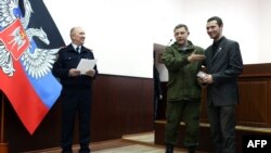 Aleksandr Zakharchenko (ortada) pasport alır