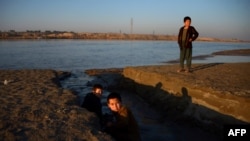 Afghan children play alongside the Amu-Darya River on the border of Afghanistan and Uzbekistan.