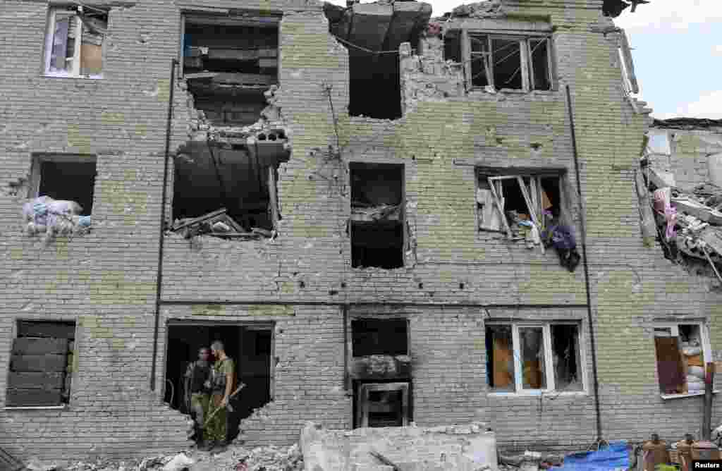 Ukrain ýaragly güýçleriniň agzalary seperatistler bilen söweşde zeper ýeten binada. Pisky, Donetsk. (Reuters/Oleksandr Klymenko)