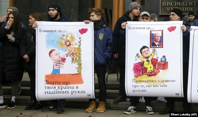 Під час акції у День святого Валентина біля Офісу президента України. На плакатах зображення керівника Офісу президента Андрія Єрмака та президентів України і Росії, Володимира Зеленського і Володимира Путіна. Київ, 14 лютого 2020 року