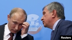 Russia -- Russian President Vladimir Putin (L) confers with his close ally Rosneft CEO Igor Sechin.