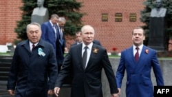 Бывший президент Казахстана Нурсултан Назарбаев (слева), президент России Владимир Путин (в центре) и премьер-министр России Дмитрий Медведев прибывают на парад на Красной площади. Москва, 9 мая 2019 года.