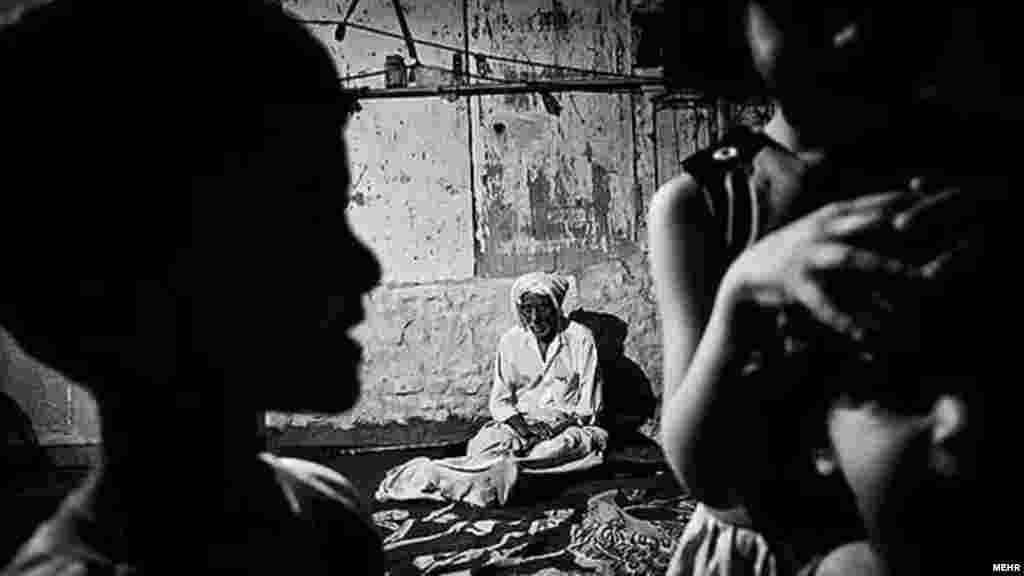 Iran – An old man and children in a room, Khorramshahr road, May2012 