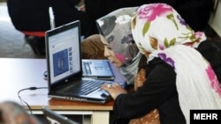 Две жительницы Ирана читают материалы в Интернете, архивное фото