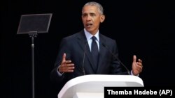 Former U.S. President Barack Obama, left, delivers his speech at the 16th Annual Nelson Mandela Lecture at the Wanderers Stadium in Johannesburg, South Africa, Tuesday, July 17, 2018.