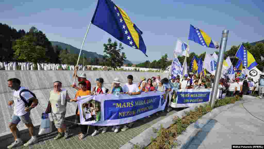 Participants in the "March for Peace" carry the Bosnian national flag as they arrive at the Memorial Center in Potocari on July 10.