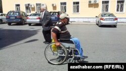 Turkmenistan. Disabled man near the "Teke" market. Cars. Ashgabat. July 7, 2015. 