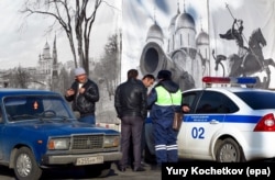 A Russian traffic policeman checks the documents of guest workers from Central Asia. (file photo)