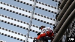 Alain Robert scales the 828-meter Burj Khalifa in Dubai.
