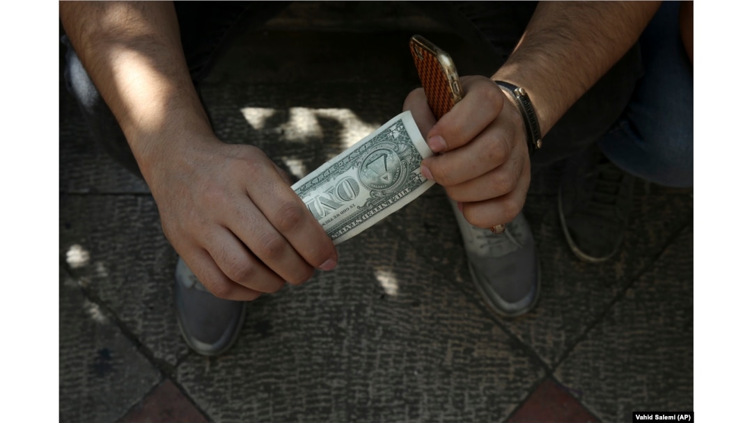 An Iranian street money changer holds a U.S. banknote in downtown Tehran earlier this month.