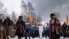 Olympic torchbearer Akhmetova Svetlana (center) waves as she holds the torch with the Olympic flame in Irkutsk on November 23. Russia is hosting the 2014 Winter Olympics in the Caucasus city of Sochi. (AFP)