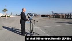 Russian President Vladimir Putin addresses Russian troops as he visits the Hmeimim military base on December 11.