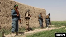 Afghan policemen keep watch during a battle with the Taliban in the Nahr-e Saraj district of Helmand Province on May 11.