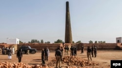 Pakistani Police inspect the brick kiln where a Christian couple was burnt alive for alleged blasphemy, in Kot Radha Kishan, near Kasur, on November 4, 2014.