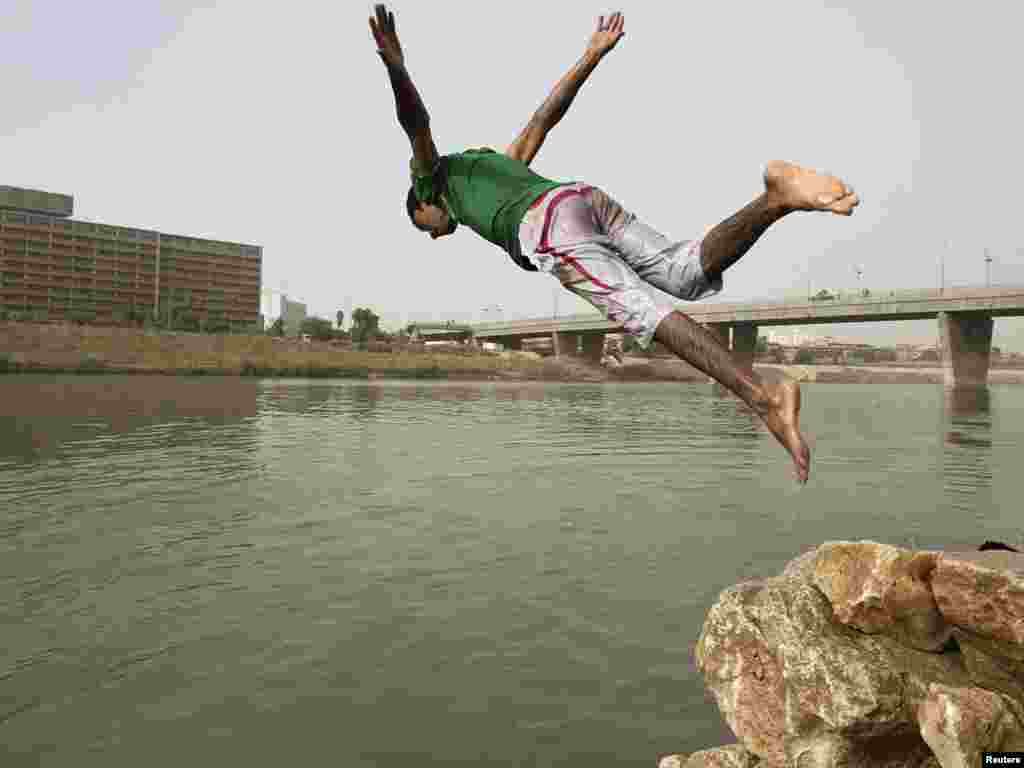 A boy jumps into the Tigris River for a swim on a warm summer day in Baghdad on July 14. Photo by Thaier al-Sudani for Reuters