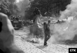 Советские солдаты пытаются потушить горящий танк, подожженный протестующими возле здания Чехословацкого радио в Праге, 21 августа 1968 года