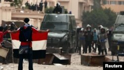 محتج مصري يرفع علم بلاده أمام وزارة الداخلية في 3/2/2012