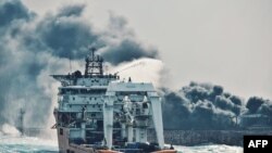 This handout picture taken on January 10 and released on January 11, 2018 by Transport Ministry of China shows a Chinese offshore supply ship "Shen Qian Hao" spraying foam on the burning oil tanker "Sanchi" at sea off the coast of eastern China.