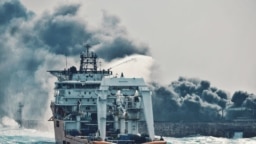 This handout picture taken on January 10 and released on January 11, 2018 by Transport Ministry of China shows a Chinese offshore supply ship "Shen Qian Hao" spraying foam on the burning oil tanker "Sanchi" at sea off the coast of eastern China.