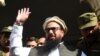 FILE: Hafiz Saeed waves to supporters as he leaves a court in Lahore in November 2017.