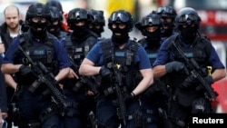 Armed police officers walk near Borough Market on June 4 after an attack left 7 people dead and dozens injured in London.