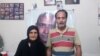 Zartosht Ahmadi Ragheb at his home near Tehran in August 2019. Behind him on the wall are photos of other imprisoned activists.