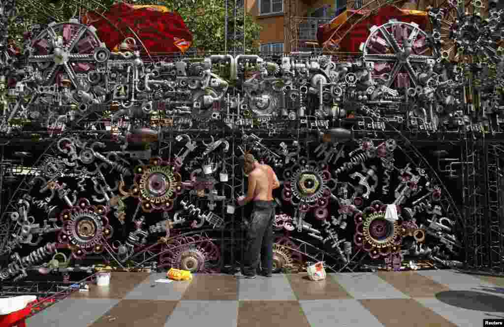 A painter works on the decoration outside a cafe bar in Prague's Holesovice district. (Reuters/Petr Jose)