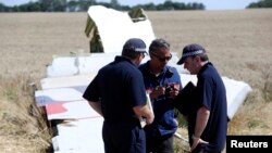 Members of a group of international experts inspect wreckage at the MH17 crash site in the Donetsk region of eastern Ukraine on August 1.