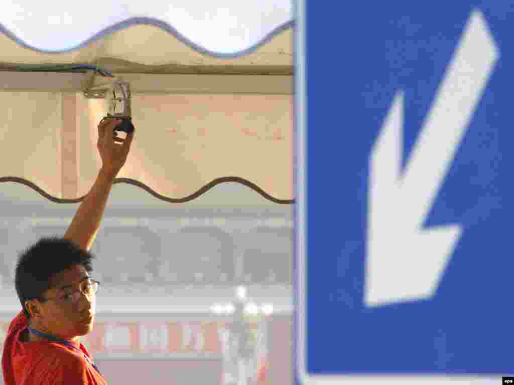 China -- A plain cloth policemen adjusts a camera at the entrance of Tiananmen Square in Beijing, 04Jun2009 - Caption: epa01750553 A plain cloth policemen adjusts a camera at the entrance of Tiananmen Square in Beijing, China, early 04 June 2009. As June 04 marks the 20-year-anniversary of the 1989 Tiananmen Square military crackdown authorities have raised the security level in that area to a maximum and denied access for western journalists