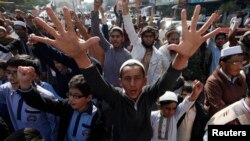 People chant slogans to condemn the December 16 attack on the Army Public School in Peshawar during a rally in Karachi on December 17.