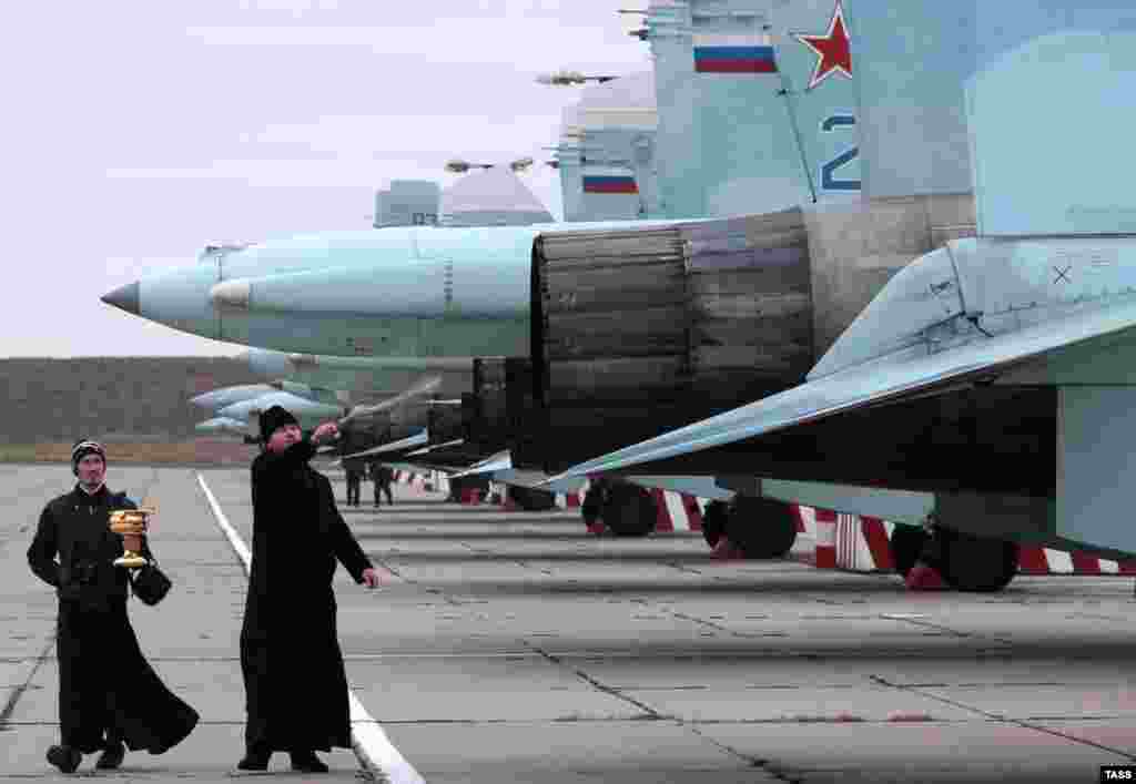 A Russian Orthodox priest blesses 10 Russian SU-27 SM fighter jets on an airfield outside Sevastopol, Crimea. Crimean military air forces were reinforced by Russian fighter jets after NATO's top military commander warned that Russia's "militarization" of Crimea could be used by Moscow to exert control across the whole Black Sea region. (TASS/Aleksei Pavlishak/TASS)