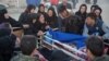 People react next to a dead body in Sarpol-e Zahab county in Kermanshah.