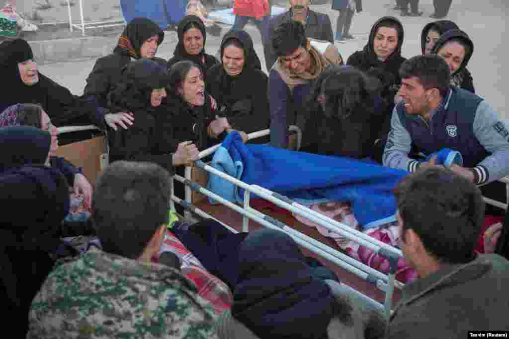 People react to a dead body in Sarpol-e Zahab.