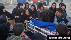 People react next to a dead body in Sarpol-e Zahab county in Kermanshah.