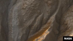 На снимке марсианского кратера, выполненном спутником Mars Reconnaissance Orbiter, видны следы потоков воды.