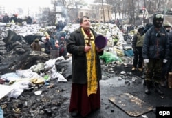 Революція гідності. Священник молиться на одній з барикад під час чергового дня антиурядового протесту в Києві, 28 січня 2014 року