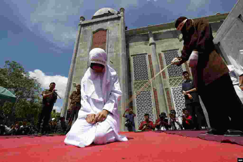 An Acehnese woman is publicly whipped at the Al-Furqon Mosque in Banda Aceh, Indonesia. Three Acehnese couples were sentenced to be whipped for violating Shari&#39;a law. (epa/Hotli Simanjuntak)