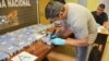 A police officer opens up a package of cocaine found in an annex building of the Russian Embassy in Buenos Aires in December 2016.