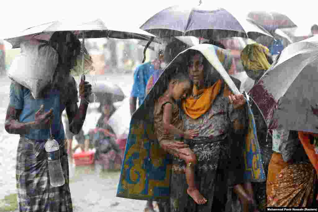 Refugees wait in the rain after being detained by border guards.