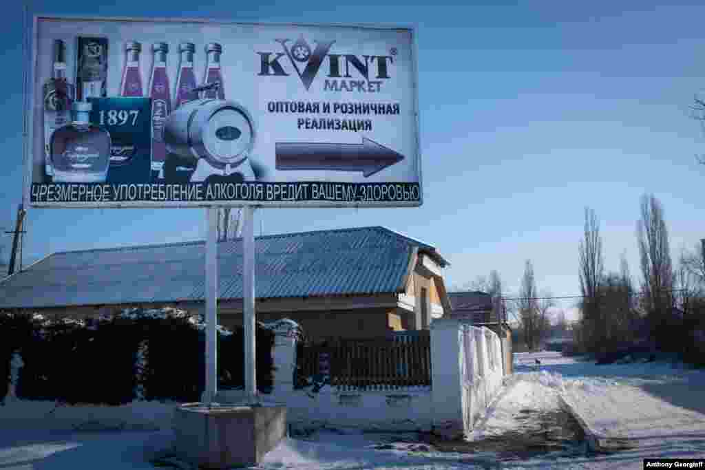 A billboard points to a shop selling local Kvint brandy.