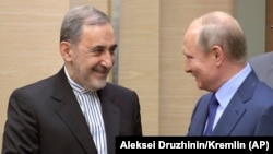 RUSSIA -- Russian President Vladimir Putin shakes hands with Ali Akbar Velayati, a senior adviser to Iran's Supreme Leader Ayatollah Ali Khamenei, at Novo-Ograyovo outside in Moscow, July 12, 2018