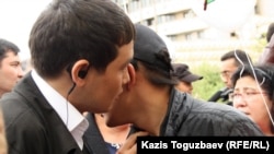 Один мужчина что-то шепчет другому на ухо во время митинга в Алматы. Иллюстративное фото. 