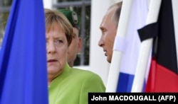 German Chancellor Angela Merkel (left) and Russian President Vladimir Putin chat as they pose for the media at Meseberg Castle on August 18.