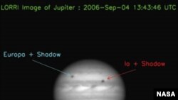 Фотография Юпитера, переданная спутником NASA New Horizons. Пятна на диске - спутники Европа и Ио.