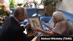 Vladimir Putin presents Lyudmila Alekseyeva with an engraving on her 90th birthday (file photo)