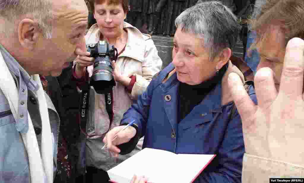 Участник Контрольной прогулки писатель Людмила Улицкая дает автографы у памятника Грибоедову.