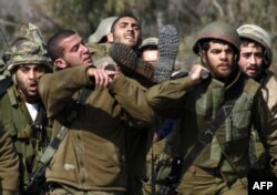 Ізраїльські військові виносять пораненого внаслідок нападу товариша, 28 січня 2015 олку